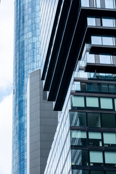 A dark balcony edge cuts across a vertical glass skyscraper facade in Frankfurt Germany, turning an office tower into measured urban architecture
