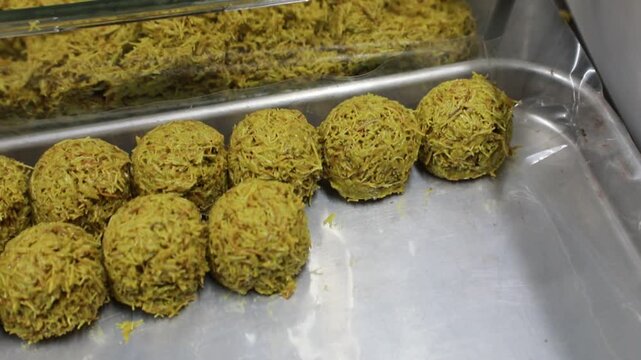 Tray containing round Dubai chewy cookie kadaif balls