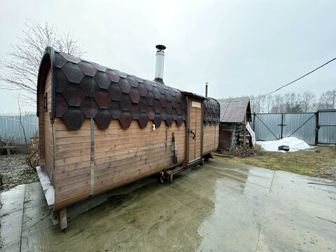 A brown-roofed sauna in a country area on a cloudy spring day