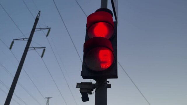 Red traffic light glowing against evening sky, urban transportation signal with copy space, road safety and city traffic control concept, minimal street infrastructure background.