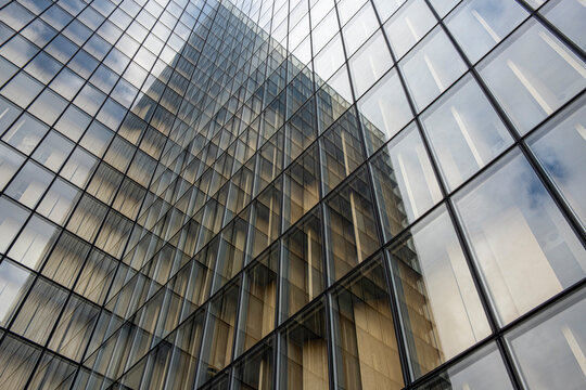 Angled reflections meet inside a glass facade where office buildings, windows and corporate architecture patterns create an abstract view