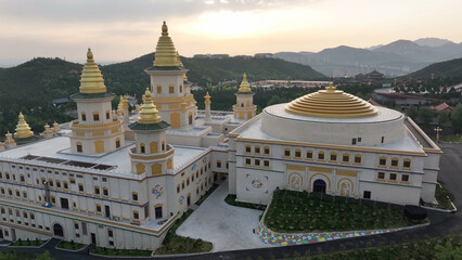 Chishan Fahua Temple complex with golden pagodas and domes in Weihai Shandong at sunset © zhu difeng