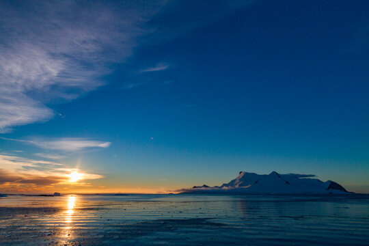 Colorful sunset skies reflect on the water near Stonington Island in Antarctica