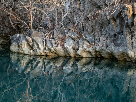Limestone formations reflected in brackish lagoon water near Anjajavy Private Reserve in Madagascar reveal nature's structure and color