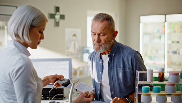 Apothecary staff scanner pills selling man store closeup. Senior client cashier
