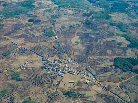 Charter flight view over a village in Madagascar showcasing farmland and rural landscape during daytime