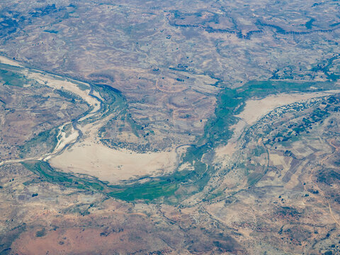 Charter flight view of a river winding through mountains in Madagascar showcasing the landscape