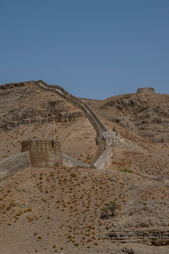 Ranikot fort stands on the mountain range overlooking the dry landscape in Sindh, Pakistan during a clear day