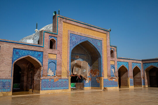 Beautifully decorated entrance of Shah Jahan Mosque in Thatta Sindh Pakistan showing intricate tile work under bright blue sky