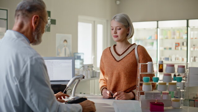 Pharmacy client paying terminal using credit card closeup. Woman buying medicine