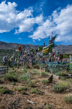 Visiting the War Cemetery in Bamyian Afghanistan where flags mark the graves and mountains stand in the distance