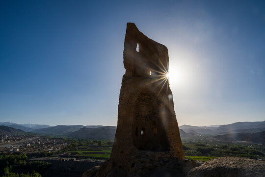 Backlight shines through the ruins of the City of Screams in Bamiyan, Afghanistan at sunset