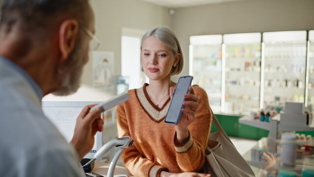 Pharmacy worker proposing pills on cashier closeup. Specialist looking screen