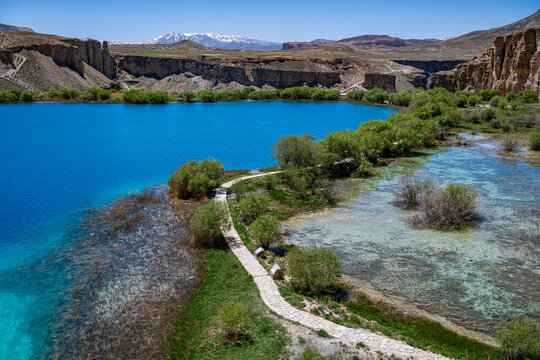 Exploring multi colored lakes in Band-e-Amir National Park with clear blue water and lush green plants in Afghanistan