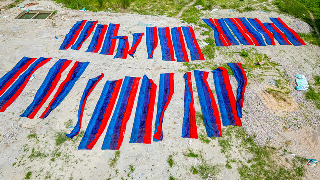 Freshly dyed cloths laid out for drying in Araihazar village, Bangladesh showing vibrant colors and traditional dyeing methods
