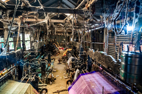 Inside a looming factory in Araihazar village, workers operate machines and produce textiles during the day while dust settles in the air