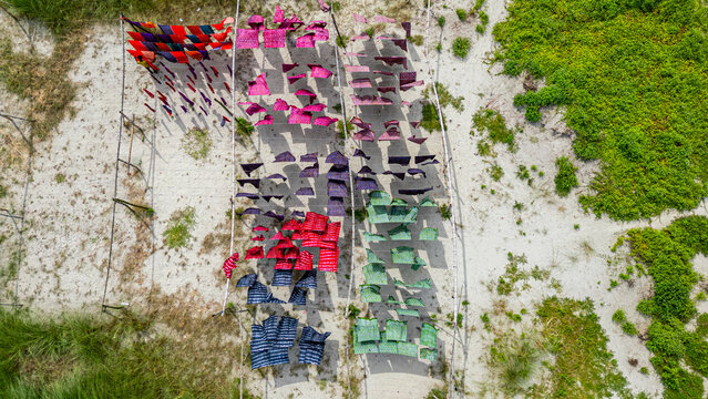 Freshly dyed cloths drying in the sun in Araihazar village in Bangladesh with various colors spread out on lines