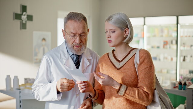 Doctor customer discussing medicine recommendation at pharmacy. Pharmacist help