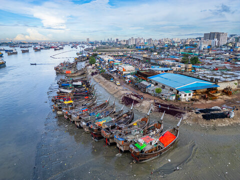 Fish market activities in Chittagong, Bangladesh, showcasing boats and local trade on a busy day