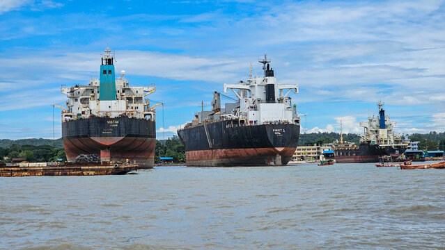 Shipwreck cemetery in Chittagong shows abandoned vessels in water under bright sky