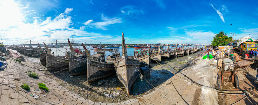 Boats anchor along the Karnaphuli River at a fish market in Chittagong, Bangladesh during the day