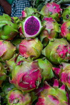 Colorful dragon fruits at a bustling vegetable market in Dhaka, showcasing local produce and vibrant colors