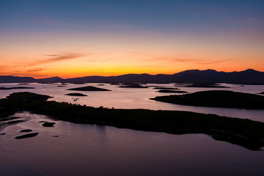 Aerial sunset view over Clew Bay near Westport, County Mayo, Ireland. Scenic Atlantic bay with drumlin islands and mountain silhouettes on the Wild Atlantic Way.