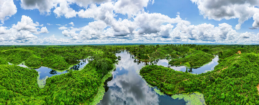 Vast green landscape of the Sreemangal tea region in Bangladesh showcasing lakes and hills under a blue sky