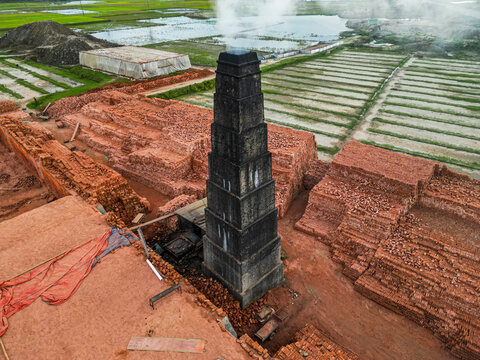 Factory produces bricks in Dhaka, Bangladesh, showcasing production processes and industrial setup with smoke releasing from chimney