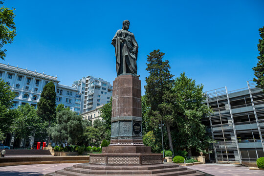Nizami Ganjavi Monument stands tall in a city square under clear blue sky in Baku, Azerbaijan