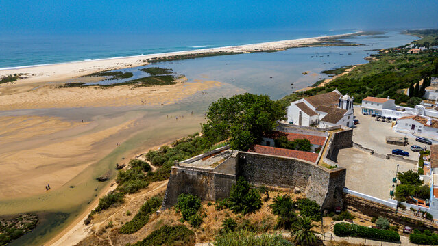 Historic village Cacela Velha offers views of coastline and river in Faro, Portugal during sunny weather