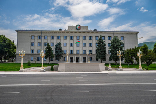 Government building in Khankendi with flags and trees on a clear day in Qarabaqh region of Azerbaijan