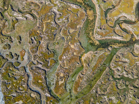 Sandy wetlands viewed from above in Algarve region of Portugal showcasing winding waterways and natural landscape patterns
