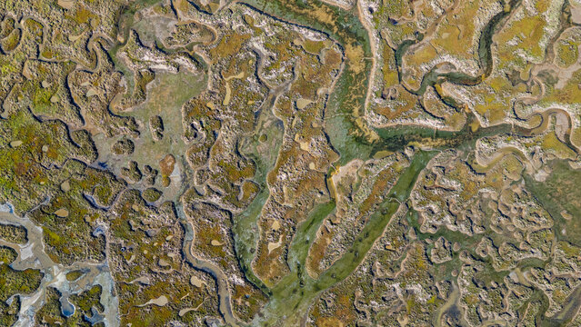 Sandy wetlands with winding waterways in Olhao, Algarve, Portugal during daytime