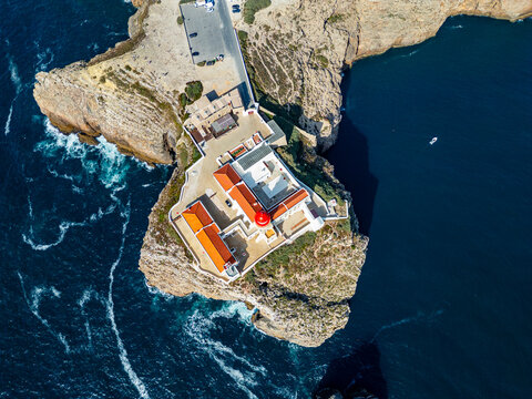Cabo de Sao Vicente lighthouse located on a cliff in Sagres overlooking the ocean in Algarve, Portugal during daylight hours