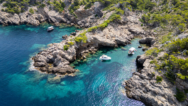 Views of the Alcudia peninsula showcasing rocky shores and clear turquoise waters in Mallorca, Spain