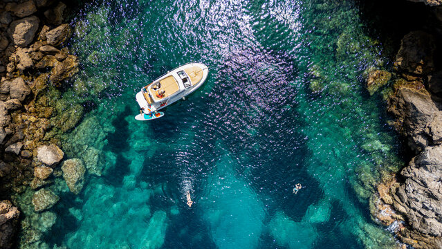 Turquoise waters and boat activity seen from above at Alcudia peninsula in Mallorca, Spain