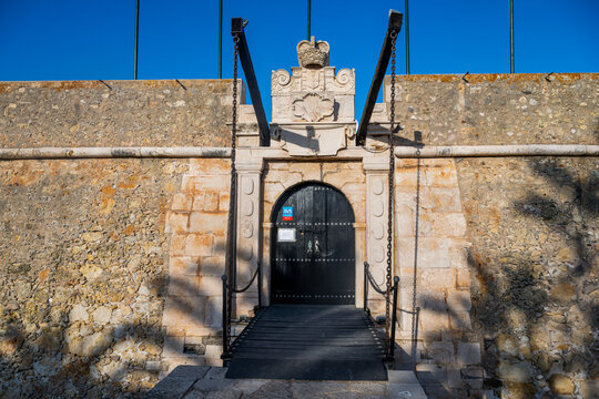 Entrance gate at Ponta da Bandeira fort in Lagos with blue sky and stone wall visible in the background for exploration and history enthusiasts