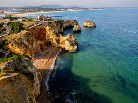 Sunset over beach cliffs near Lagos in Algarve, showcasing natural rock formations and the coastline
