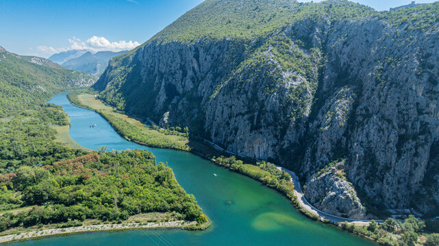 View shows Cetina gorge and river with green banks and steep cliffs in Croatia