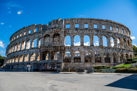 Roman amphitheatre stands in Pula showing stone architecture and arches during a sunny day in Croatia