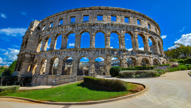 Roman amphitheatre in Pula stands tall under blue skies in Istria, Croatia