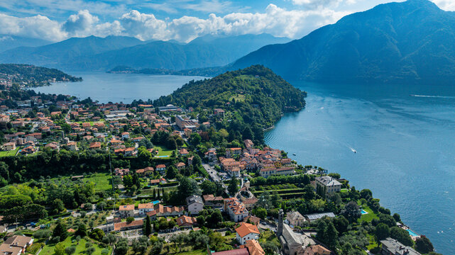 Aerial view of Lenno at Lake Como in Italy showing hills, water, homes, and green fields, offering a glimpse of daily life and landscape features