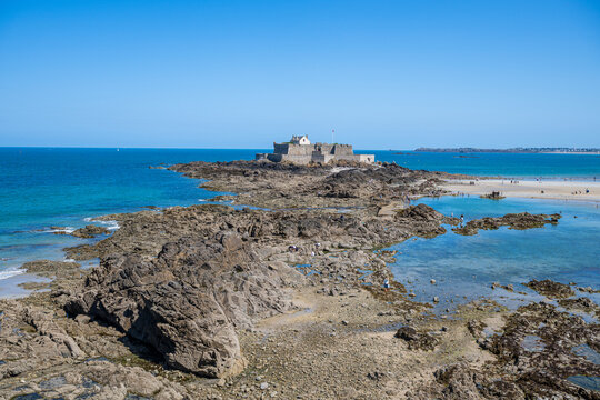 View of a small fortress surrounded by water, located in the Walled city of Saint-Malo, Brittany, France during a sunny day