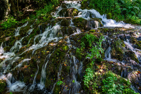 Water flows over rocks and greenery at Strbacki buk waterfall in Una National Park in Bosnia and Herzegovina