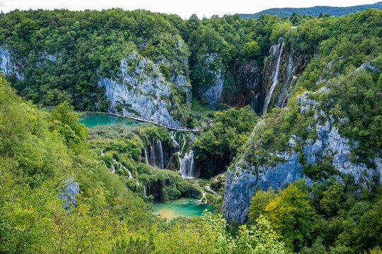 Waterfalls and lakes flow through green forests in an outdoor setting in Croatia's national park