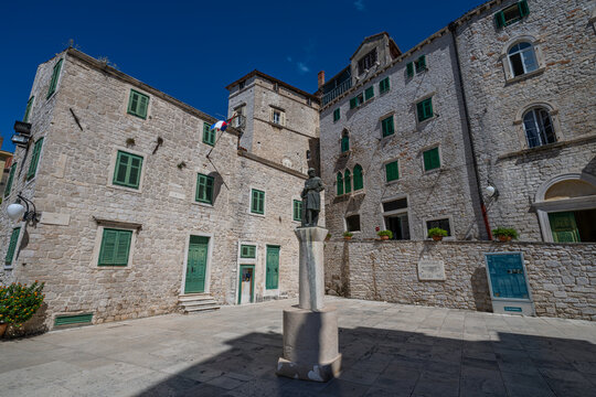 Exploring the narrow streets of the old city in Sibenik Croatia with stone buildings and a statue