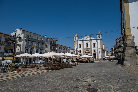 Exploring the historical square in the old city of Evora with empty market stalls during daylight