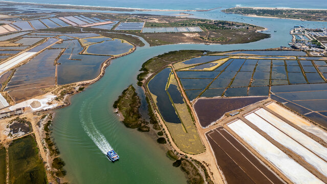 View of saltpans and waterways in Tavira, Algarve, with boats navigating through the landscape