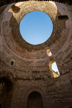 Exploring the ancient cellars of Diocletians Palace in Split, Croatia with a view of the sky through the dome